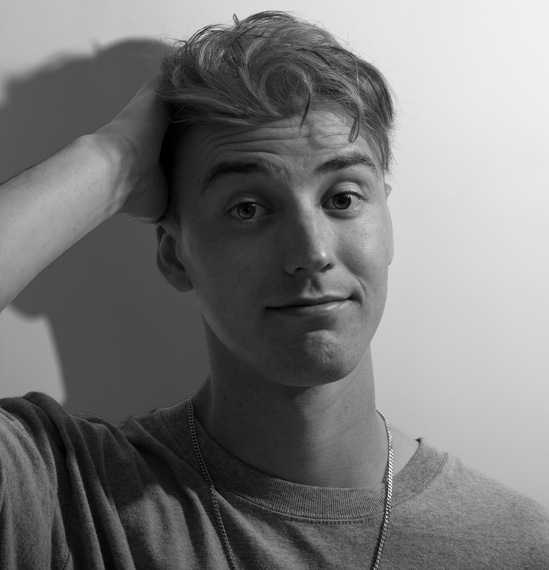 Young man pushing hand through hair